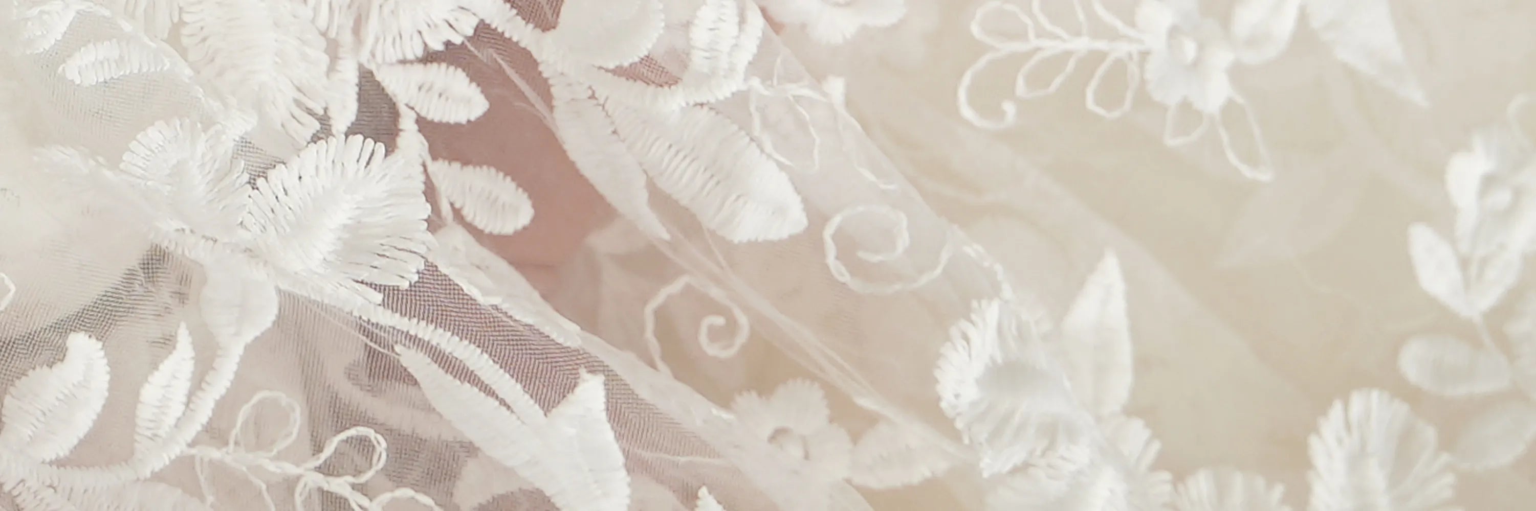 Detailaufnahme der 3D-Stickerei eines eleganten Baby-Taufkleids.