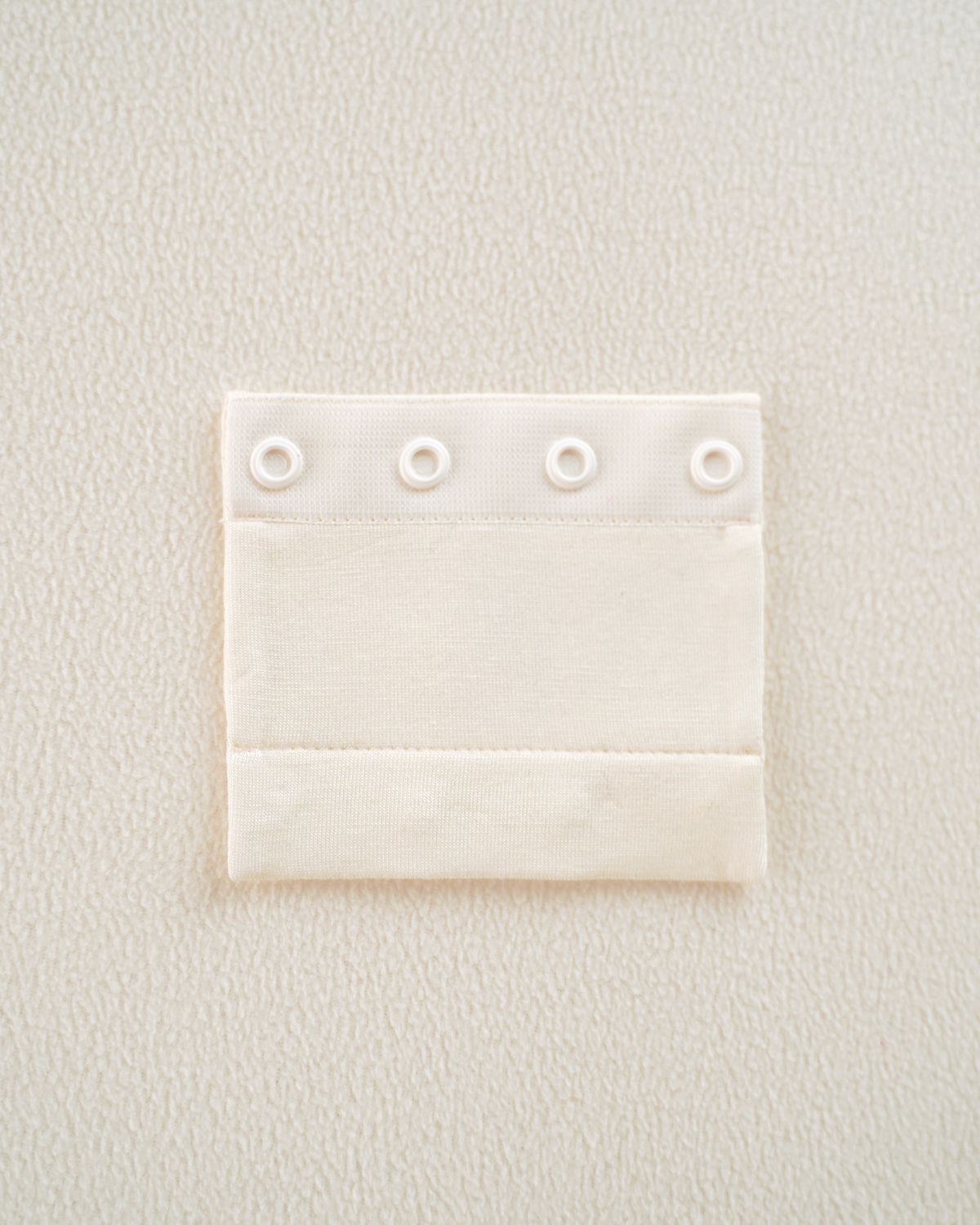 Detailaufnahme der CUCOONU Bodyverlängerung am festlichen Babybody ‚Vanilla Dream‘