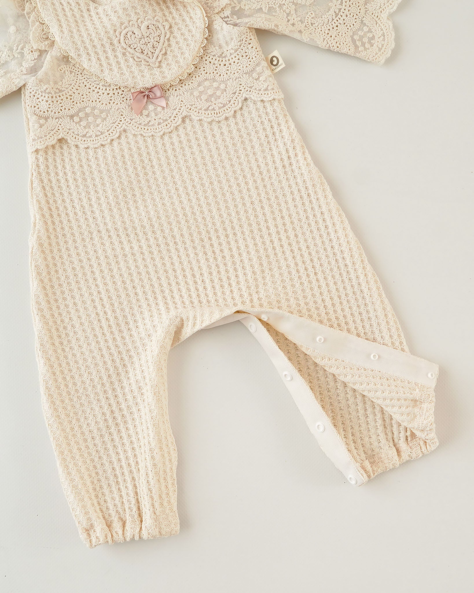 Festlicher Cucoonu Babystrampler in Creme, Verschluss im Schritt, Nahaufnahme