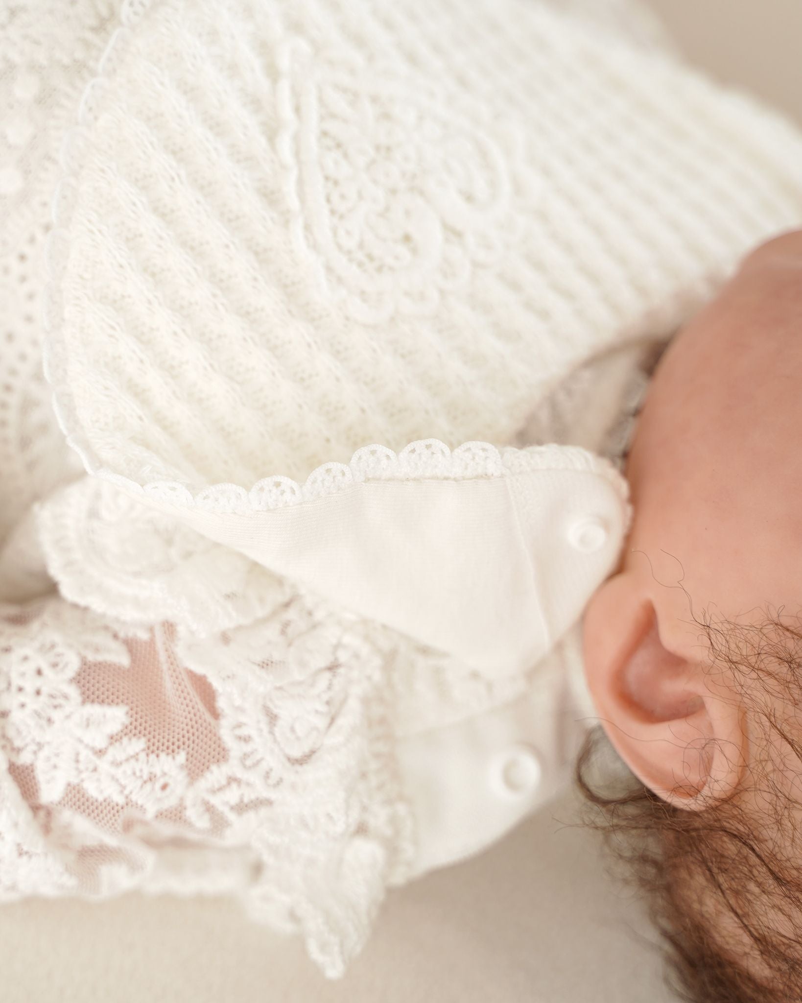 Detailaufnahme des Lätzchenverschlusses an einem festlichen CUCOONU Babybody