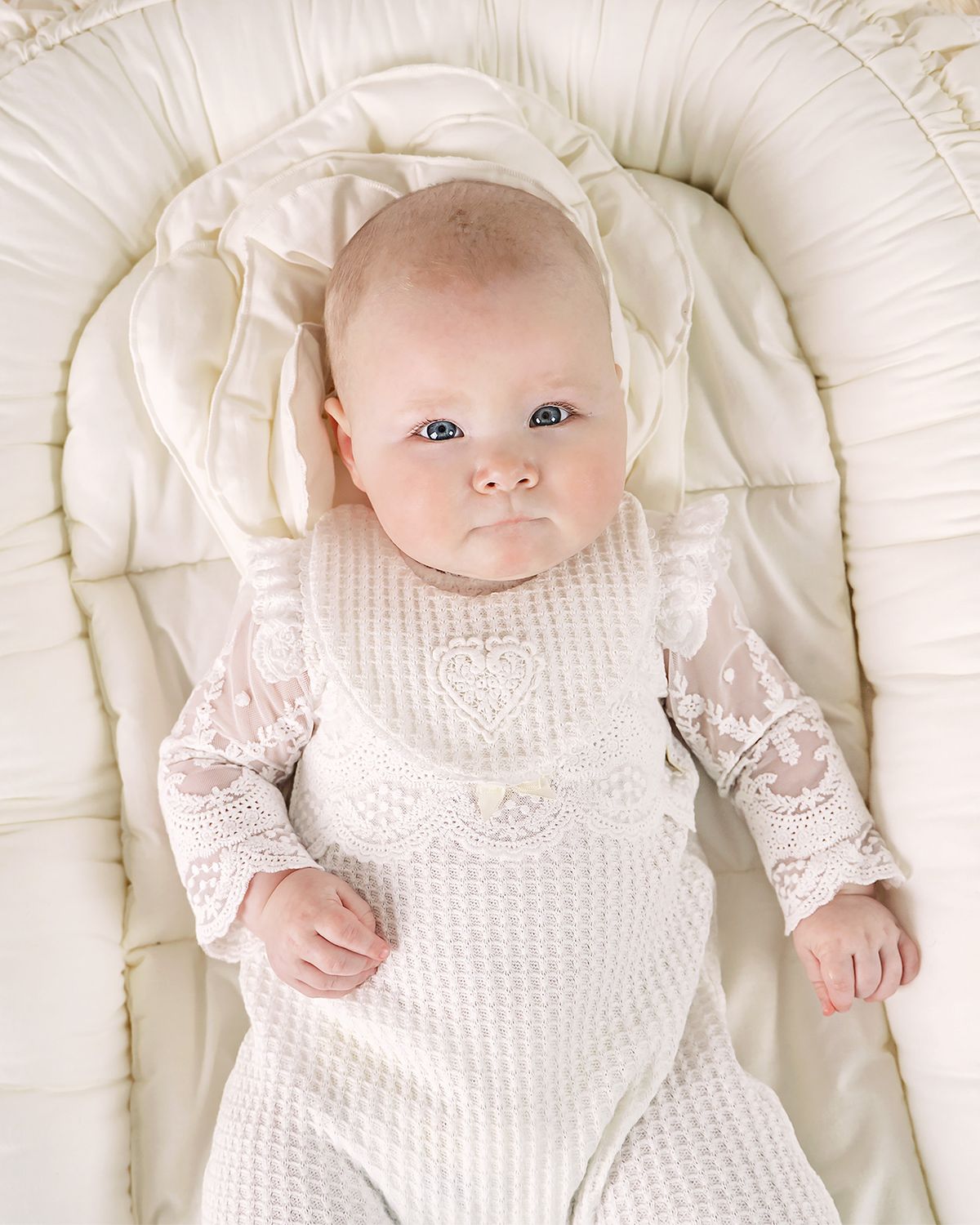 Baby in einem hochwertigen Cucoonu Taufoutfit in Offwhite