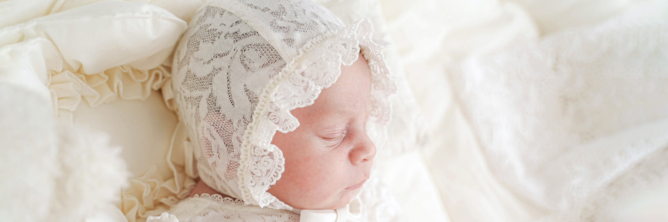Babyköpfchen mit festlicher Babymütze aus Spitze
