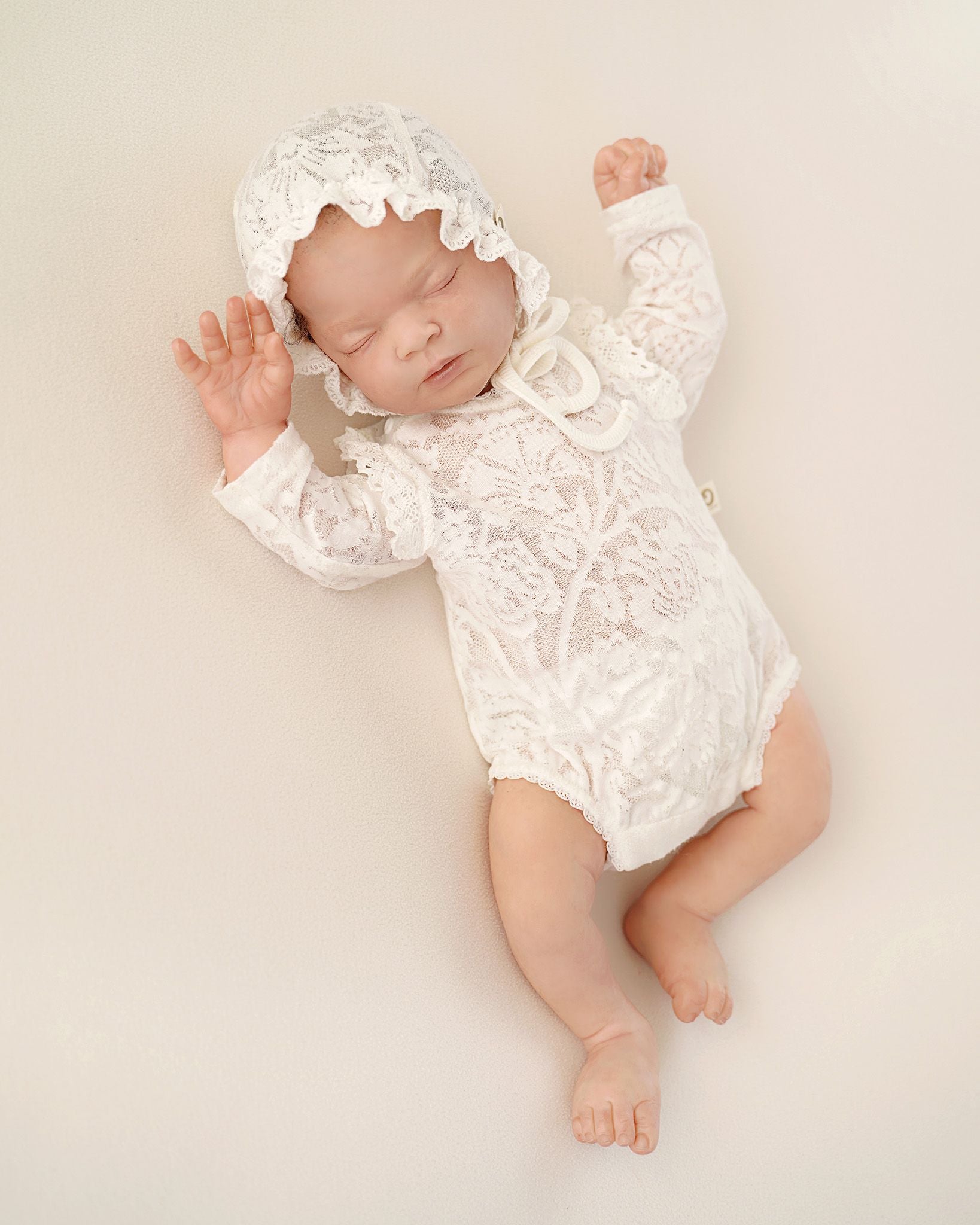 Baby trägt festliches CUCOONU Outfit: Body und Mütze aus Seiden-Jersey-Jacquard