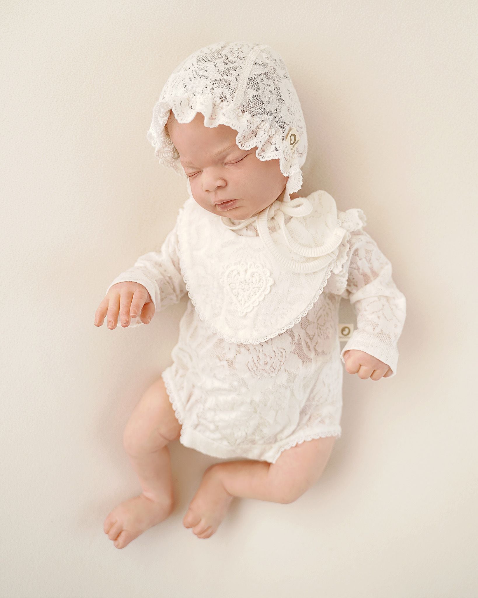 Neugeborenes Baby im CUCOONU Babybody mit passender Mütze aus Seiden-Jersey-Jacquard in Offwhite