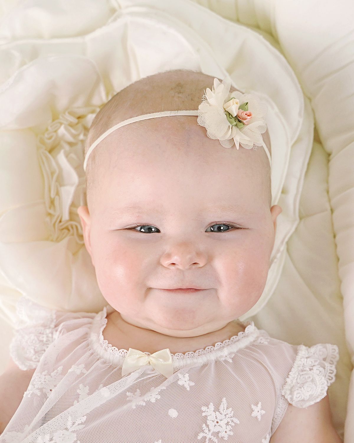 Baby trägt elegantes Haarband mit Chiffonblüten