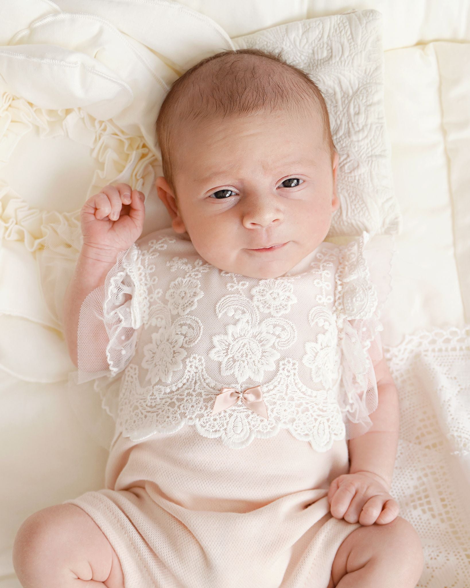 Baby trägt Cucoonu Body mit Spitze und schaut süß in die Kamera