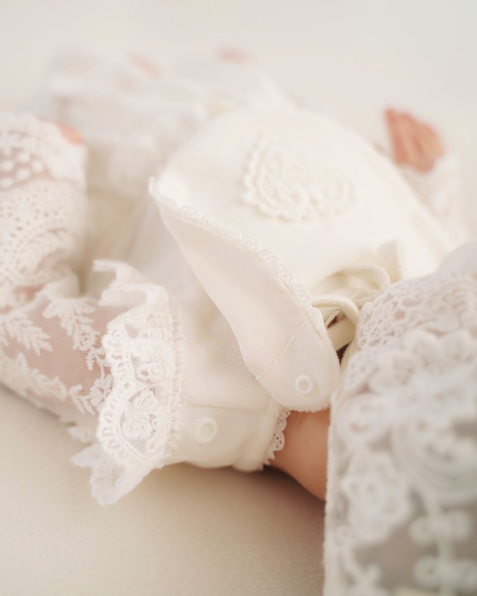 Detailaufnahme vom Lätzchenverschluss an festlichem Baby Taufkleid von Cucoonu