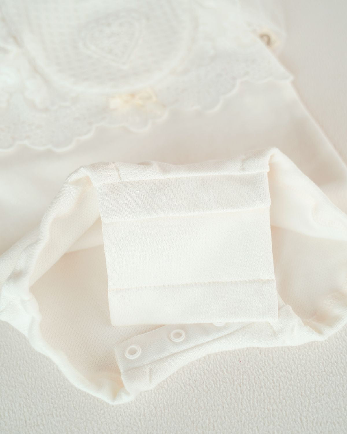 Detailaufnahme der praktischen Bodyverlängerung am CUCOONU Babybody ‚Tender Bloom‘