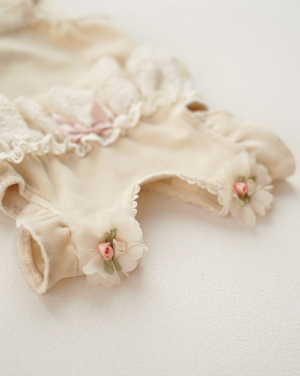 Festlicher CUCOONU Babybody mit Schulterschmuck: feine Chiffonblüte, befestigt mit Druckknöpfen