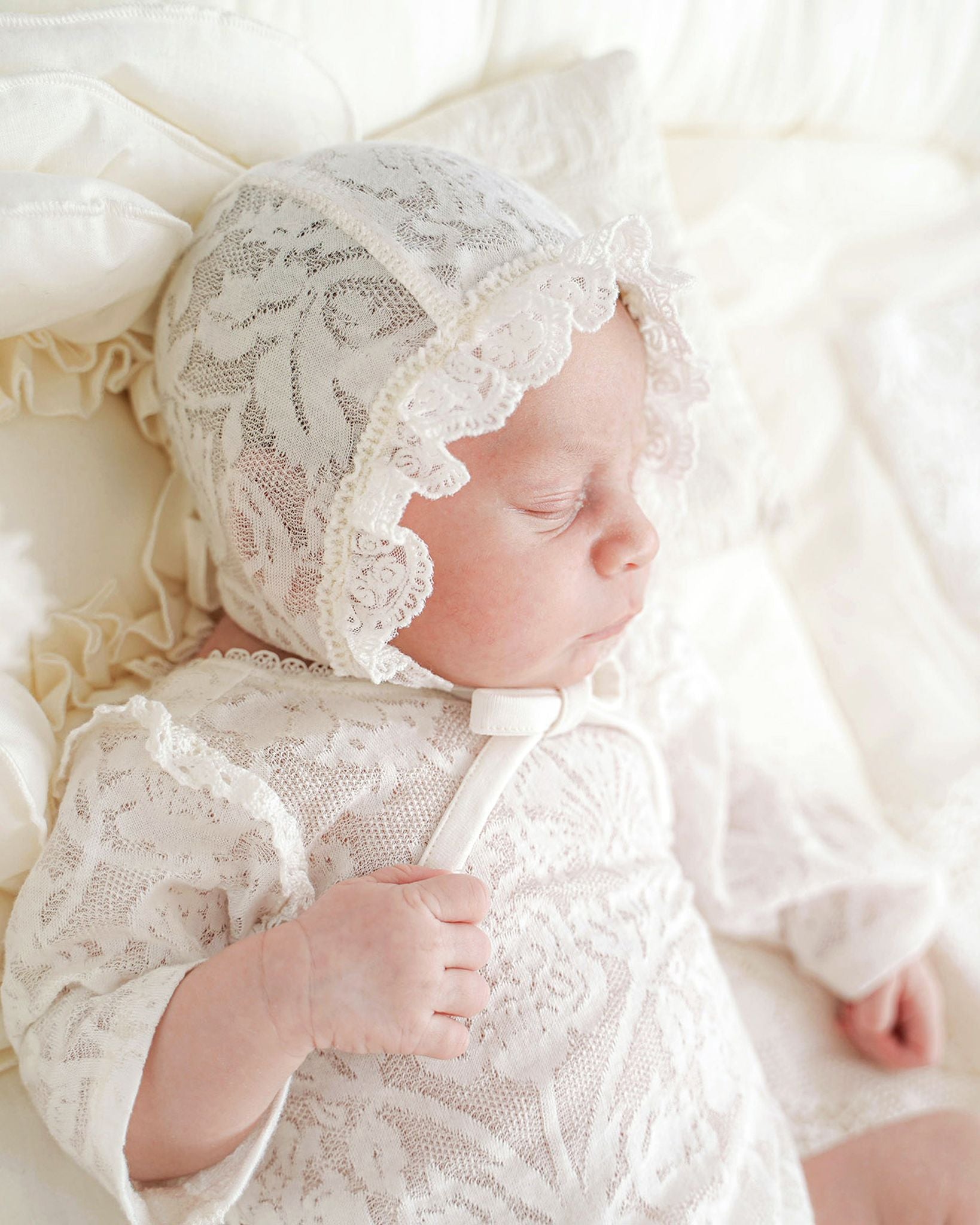 Neugeborenes schläft friedlich im festlichen Babybody mit Mütze