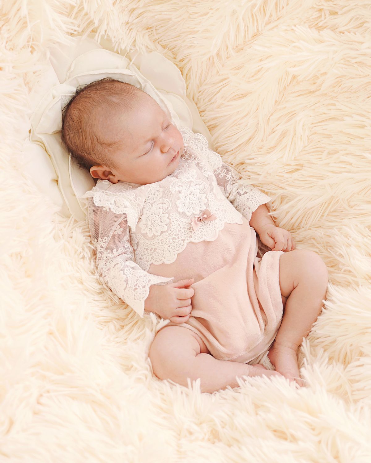 Neugeborenes Baby im festlichen CUCOONU Babybody aus Samt in Rosa mit Spitzenärmeln